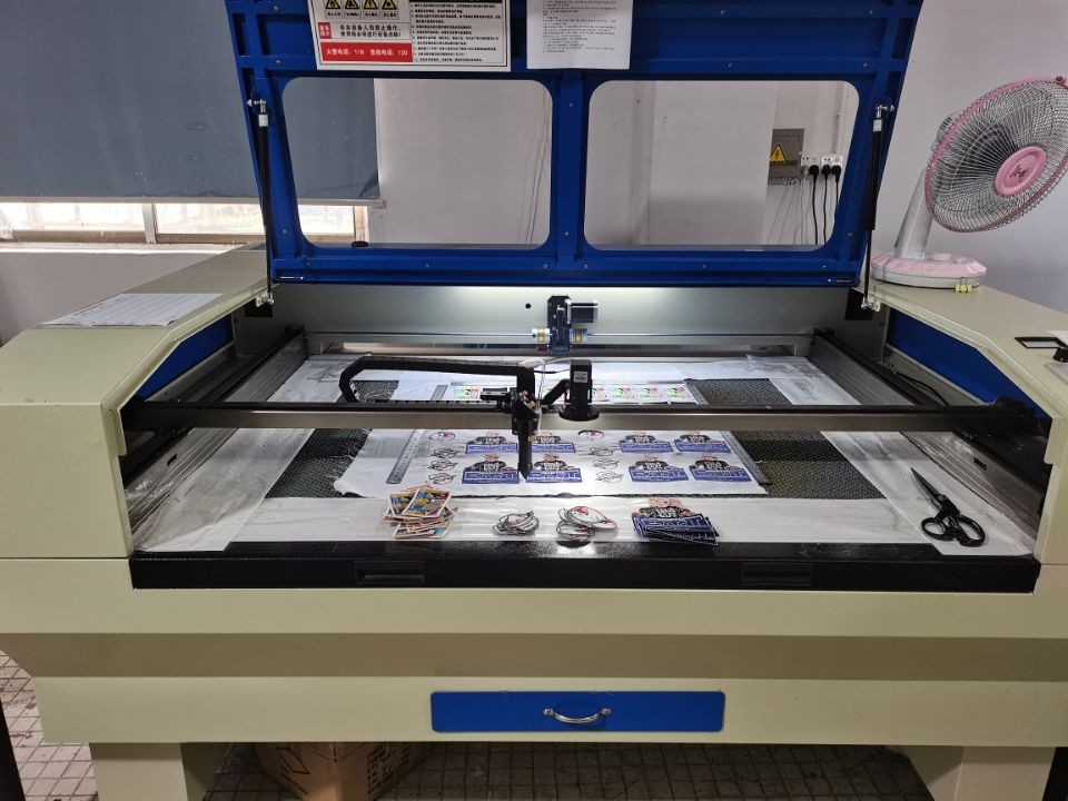 Laser cutting machine cutting custom patches at RX Custom Patch Factory
